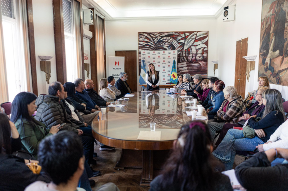 Vecinos reunidos durante una jornada de firma de escrituras de viviendas