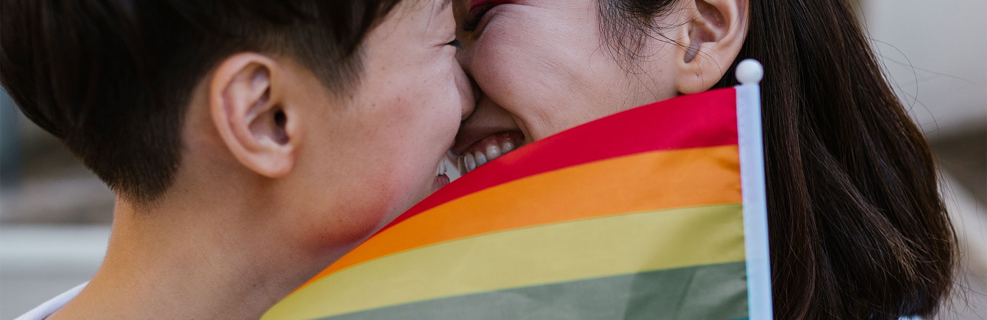Dos mujeres junto a la bandera del Orgullo LGBT, en conmemoración del Día de la Visibilidad Lésbica.